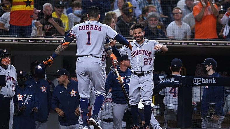 Sep 3, 2021; San Diego, California, USA; Houston Astros shortstop Carlos Correa (1) is greeted at the dugout by second baseman Jose Altuve (27) after hitting a three-run home run against the San Diego Padres during the fourth inning at Petco Park. Mandatory Credit: Orlando Ramirez-USA TODAY Sports
