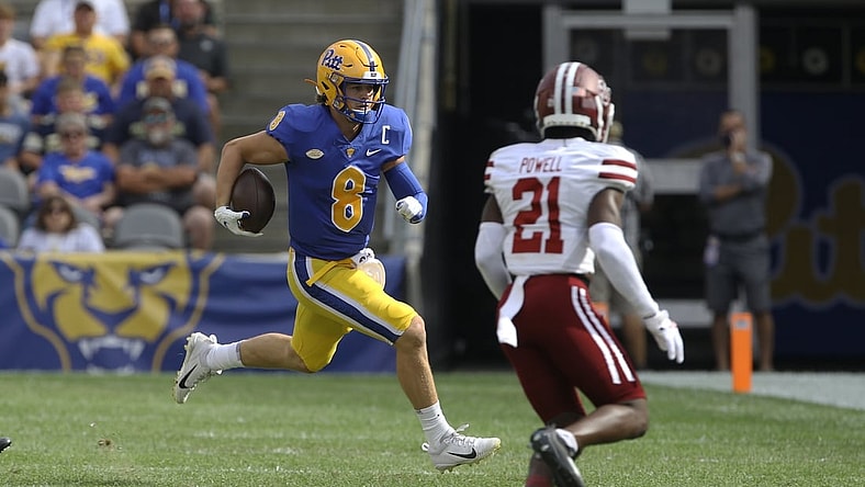 Sep 4, 2021; Pittsburgh, Pennsylvania, USA;  Pittsburgh Panthers quarterback Kenny Pickett (8) carries the ball against Massachusetts Minutemen defensive back Te'Rai Powell (21) during the first quarter at Heinz Field. Mandatory Credit: Charles LeClaire-USA TODAY Sports