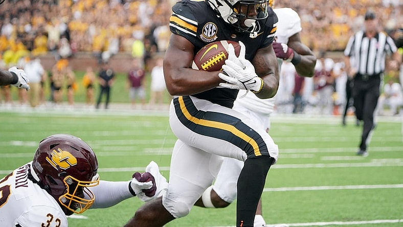 Sep 4, 2021; Columbia, Missouri, USA; Missouri Tigers running back Tyler Badie (1) scores a touchdown as Central Michigan Chippewas linebacker Nick Apsey (32) attempts the tackle during the first half at Faurot Field at Memorial Stadium. Mandatory Credit: Denny Medley-USA TODAY Sports