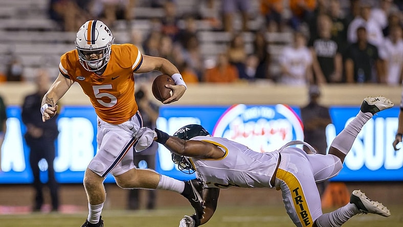 Sep 4, 2021; Charlottesville, Virginia, USA; Virginia Cavaliers quarterback Brennan Armstrong (5) scrambles against William & Mary Tribe linebacker Trey Watkins (2) during the first half at Scott Stadium. Mandatory Credit: Scott Taetsch-USA TODAY Sports