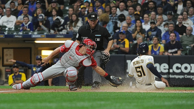 Sep 8, 2021; Milwaukee, Wisconsin, USA;  Milwaukee Brewers relief pitcher Freddy Peralta (51) slides in safely into home plate against the Philadelphia Phillies catcher J.T. Realmuto (10) in the second inning at American Family Field. Mandatory Credit: Michael McLoone-USA TODAY Sports