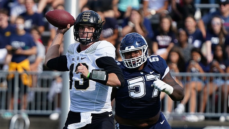 Sep 11, 2021; East Hartford, Connecticut, USA;  Purdue Boilermakers quarterback Jack Plummer (13) throws a pass under pressure from Connecticut Huskies defensive lineman Travis Jones (57) in the first half at Rentschler Field at Pratt & Whitney Stadium. Mandatory Credit: David Butler II-USA TODAY Sports