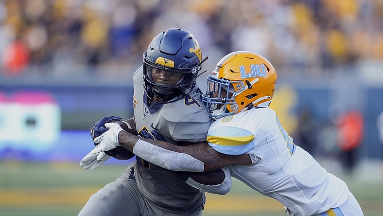 Sep 11, 2021; Morgantown, West Virginia, USA; West Virginia Mountaineers running back Leddie Brown (4) is tackled by Long Island Sharks safety Jerome Brooks III (6) during the second quarter at Mountaineer Field at Milan Puskar Stadium. Mandatory Credit: Ben Queen-USA TODAY Sports