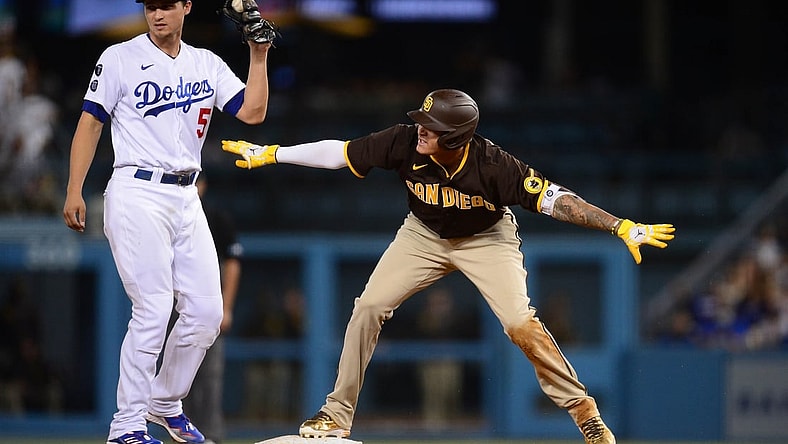 September 11, 2021; Los Angeles, California, USA; San Diego Padres third baseman Manny Machado (13) reacts after reaching second against Los Angeles Dodgers shortstop Corey Seager (5) on a double hit during the sixth inning at Dodger Stadium. Mandatory Credit: Gary A. Vasquez-USA TODAY Sports