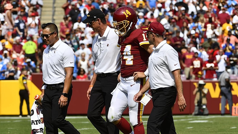 Sep 12, 2021; Landover, Maryland, USA; Washington Football Team quarterback Ryan Fitzpatrick (14) is helped off the field after suffering an injury during the second quarter against the Los Angeles Chargers at FedExField. Mandatory Credit: Brad Mills-USA TODAY Sports