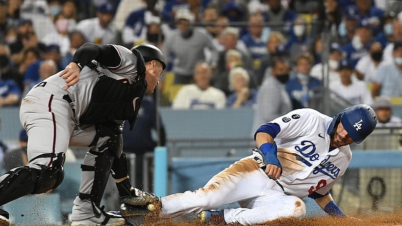 Sep 13, 2021; Los Angeles, California, USA; Los Angeles Dodgers second baseman Gavin Lux (9) is out at home trying to score against Arizona Diamondbacks catcher Carson Kelly (18) in the fourth inning on a sacrifice fly hit by Los Angeles Dodgers right fielder Mookie Betts (not pictured)  at Dodger Stadium. Mandatory Credit: Richard Mackson-USA TODAY Sports