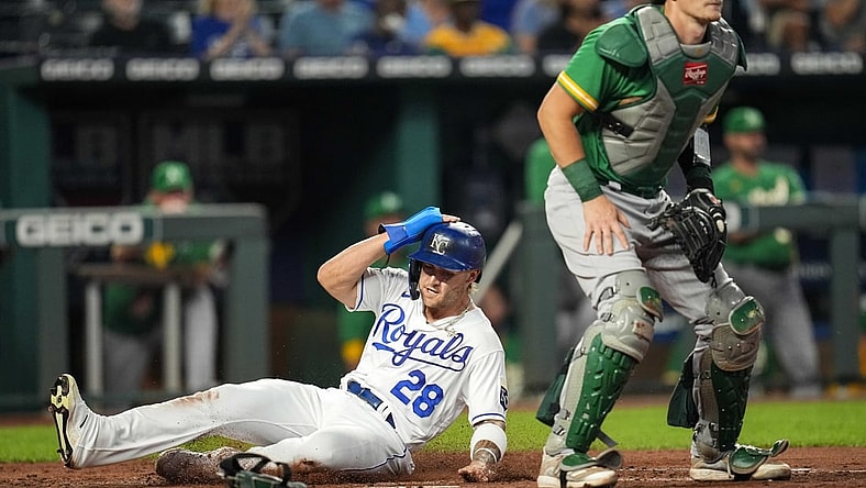 Sep 14, 2021; Kansas City, Missouri, USA; Kansas City Royals center fielder Kyle Isbel (28) slides into home plate to score as Oakland Athletics catcher Sean Murphy (12) awaits the throw during the third inning at Kauffman Stadium. Mandatory Credit: Jay Biggerstaff-USA TODAY Sports