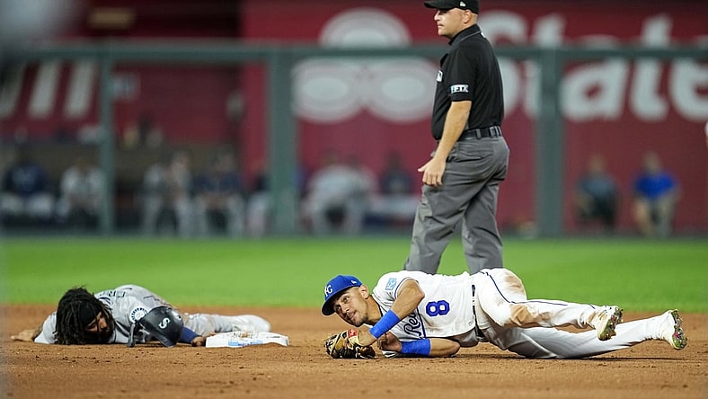 Sep 17, 2021; Kansas City, Missouri, USA; Seattle Mariners shortstop J.P. Crawford (left) reacts after he is caught stealing by Kansas City Royals shortstop Nicky Lopez (8) during the third inning at Kauffman Stadium. Mandatory Credit: Jay Biggerstaff-USA TODAY Sports