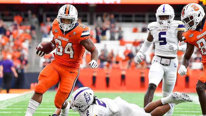 Sep 18, 2021; Syracuse, New York, USA; Syracuse Orange running back Sean Tucker (34) runs with the ball past the tackle attempt of Albany Great Danes defensive back Tyler Carswell (2) during the first half at the Carrier Dome. Mandatory Credit: Rich Barnes-USA TODAY Sports