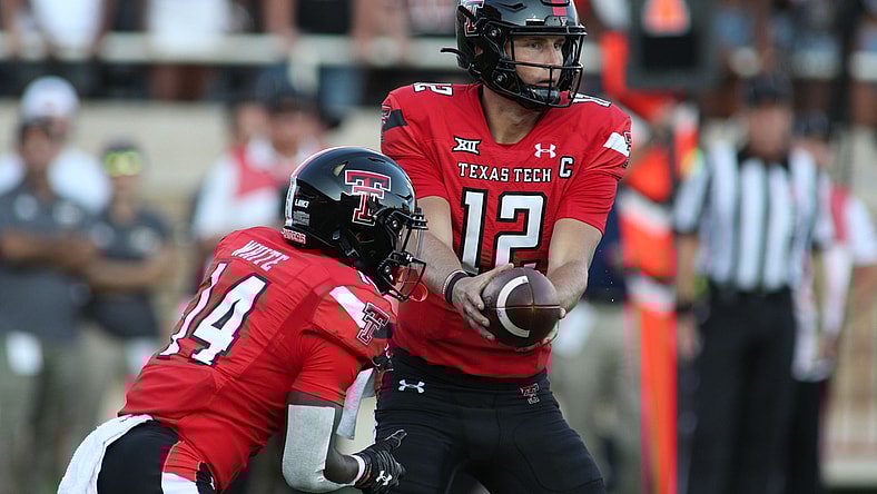 Sep 18, 2021; Lubbock, Texas, USA; Texas Tech Red Raiders quarter back Tyler Shough (12) hands off to running back Xavier White (14) against the Florida International Panthers during the first half at Jones AT&T Stadium. Mandatory Credit: Michael C. Johnson-USA TODAY Sports