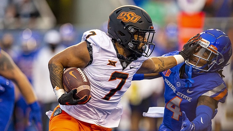 Sep 18, 2021; Boise, Idaho, USA;  Boise State Broncos safety Rodney Robinson (4) gets a stiff arm from Oklahoma State Cowboys running back Jaylen Warren (7) during the first half of play  at Albertsons Stadium. Mandatory Credit: Brian Losness-USA TODAY Sports
