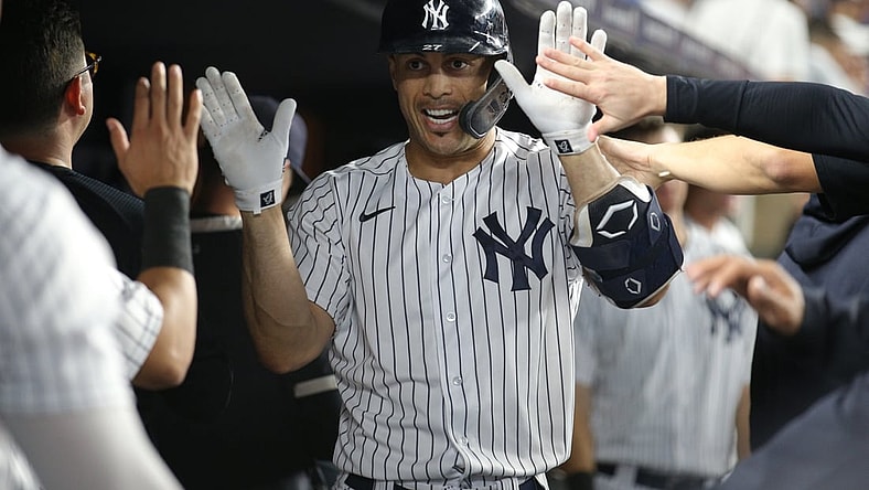 Sep 21, 2021; Bronx, New York, USA; New York Yankees right fielder Giancarlo Stanton (27) celebrates in the dugout with teammates after hitting a solo home run against the Texas Rangers during the third inning at Yankee Stadium. Mandatory Credit: Brad Penner-USA TODAY Sports