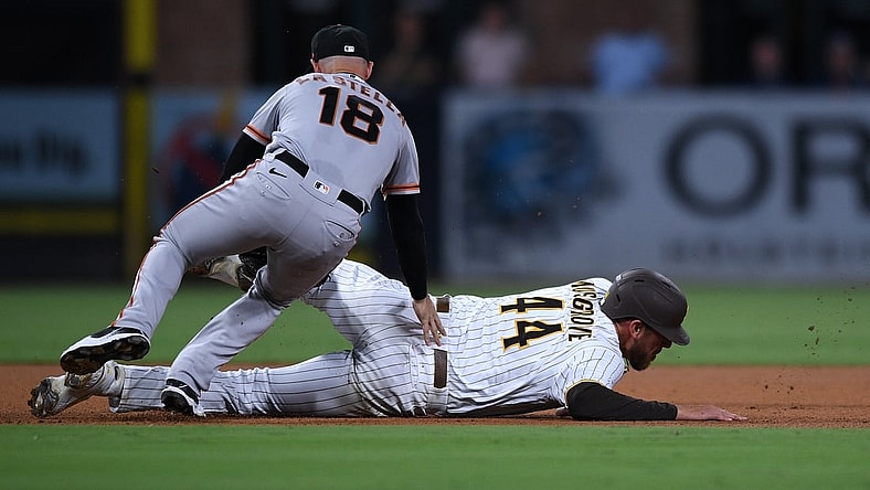 Sep 21, 2021; San Diego, California, USA; San Diego Padres starting pitcher Joe Musgrove (44) is tagged out by San Francisco Giants second baseman Tommy La Stella (18) after being caught in a rundown during the fourth inning at Petco Park. Mandatory Credit: Orlando Ramirez-USA TODAY Sports