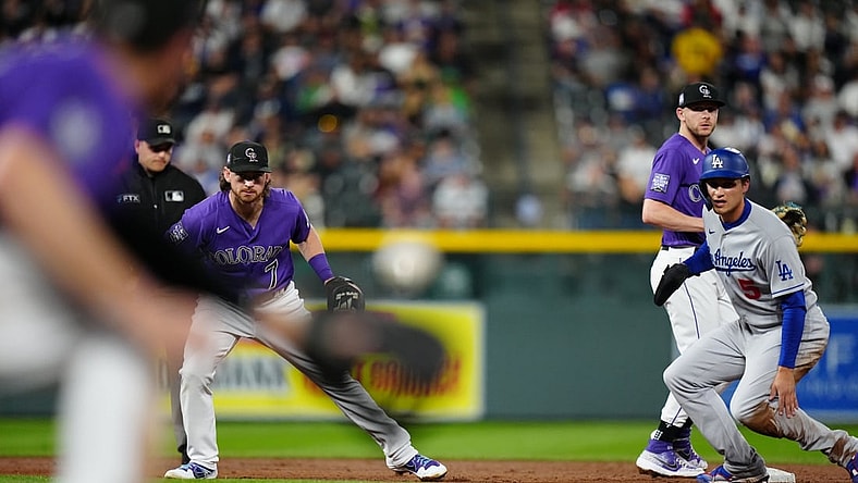 Sep 22, 2021; Denver, Colorado, USA; Los Angeles Dodgers shortstop Corey Seager (5) and Colorado Rockies shortstop Brendan Rodgers (7) and shortstop Trevor Story (27) look back to see the baseball in the fourth inning against the Colorado Rockies at Coors Field. Mandatory Credit: Ron Chenoy-USA TODAY Sports