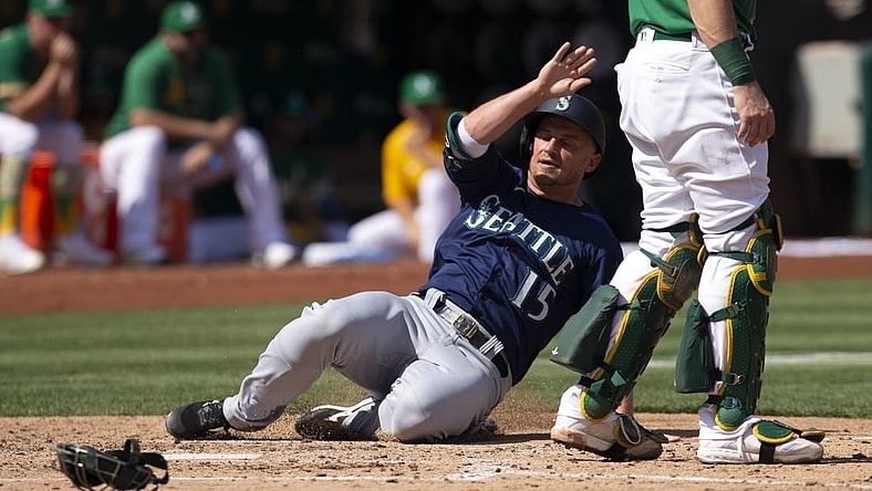 Sep 23, 2021; Oakland, California, USA; Seattle Mariners designated hitter Kyle Seager (15) slides safely home on an RBI double by Abraham Toro during the fourth inning against the Oakland Athletics at RingCentral Coliseum. Mandatory Credit: D. Ross Cameron-USA TODAY Sports
