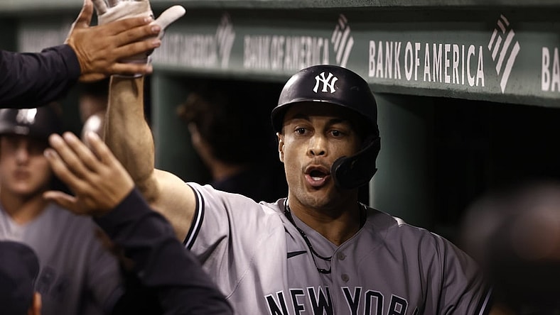 Sep 24, 2021; Boston, Massachusetts, USA; New York Yankees designated hitter Giancarlo Stanton (27) is greeted in the dugout after his three run home run against the Boston Red Sox during the third inning at Fenway Park. Mandatory Credit: Winslow Townson-USA TODAY Sports