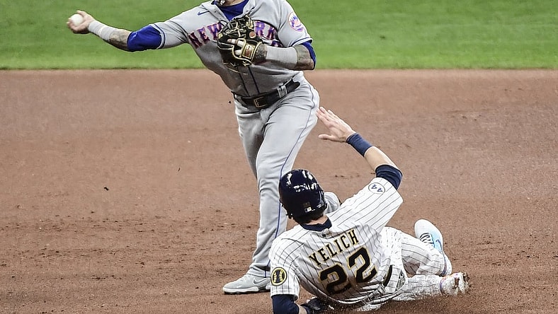 Sep 24, 2021; Milwaukee, Wisconsin, USA; Milwaukee Brewers left fielder Christian Yelich (22) breaks up a double play attempt by New York Mets shortstop Javier Baez (23) in the first inning at American Family Field. Mandatory Credit: Benny Sieu-USA TODAY Sports