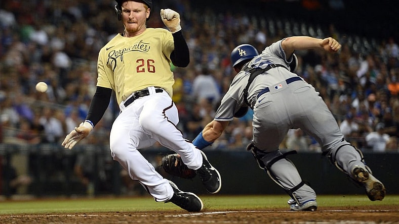 Sep 24, 2021; Phoenix, Arizona, USA; Arizona Diamondbacks first baseman Pavin Smith (26) scores a run as a throw gets away from Los Angeles Dodgers catcher Will Smith (16) during the fifth inning at Chase Field. Mandatory Credit: Joe Camporeale-USA TODAY Sports
