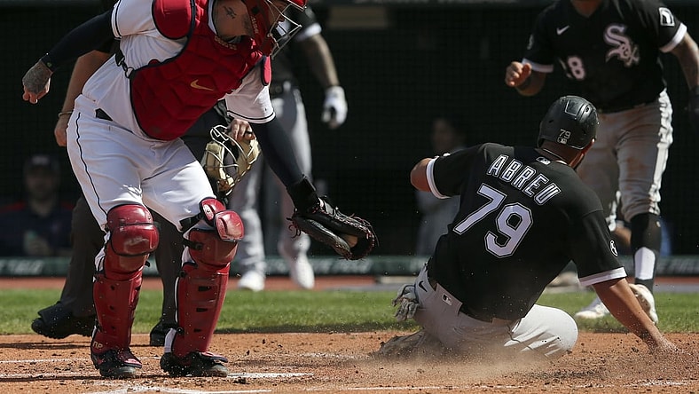 Sep 26, 2021; Cleveland, Ohio, USA;  Chicago White Sox Jose Abreu (79) slides into home plate safe ahead of the tag from Cleveland Indians catcher Roberto Prez (55) in the third inning at Progressive Field. Mandatory Credit: Aaron Josefczyk-USA TODAY Sports