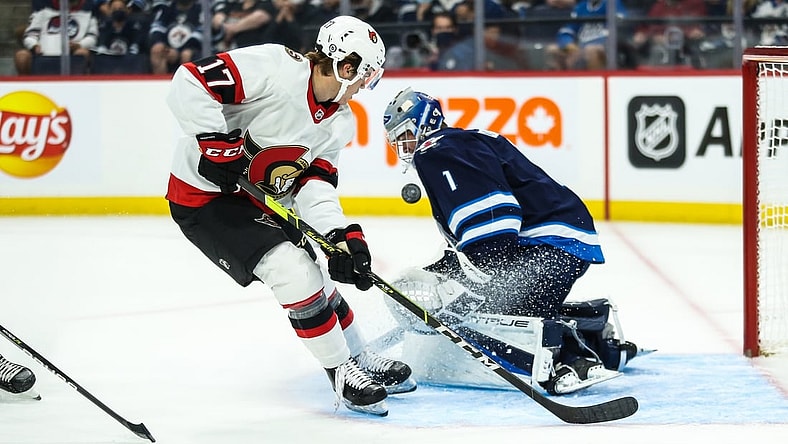 Sep 26, 2021; Winnipeg, Manitoba, CAN;  Winnipeg Jets goalie Eric Comrie (1) makes a save on Ottawa Senators forward Ridly Greig (17) during the first period at Canada Life Centre. Mandatory Credit: Terrence Lee-USA TODAY Sports