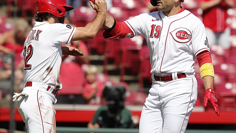 Sep 27, 2021; Cincinnati, Ohio, USA; Cincinnati Reds first baseman Joey Votto (19) reacts with left fielder Max Schrock (32) after hitting a two-run home run against the Pittsburgh Pirates during the first inning at Great American Ball Park. Mandatory Credit: David Kohl-USA TODAY Sports