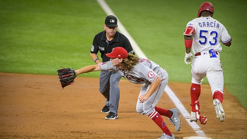 Sep 28, 2021; Arlington, Texas, USA; Texas Rangers right fielder Adolis Garcia (53) beats out the throw to first base as Los Angeles Angels starting pitcher Packy Naughton (58) covers during the second inning at Globe Life Field. Mandatory Credit: Jerome Miron-USA TODAY Sports