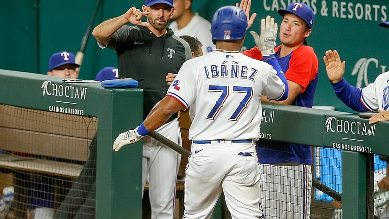 Sep 29, 2021; Arlington, Texas, USA; Texas Rangers second baseman Andy Ibanez (77) celebrates with manager Chris Woodward (8) after scoring against the Los Angeles Angels during the fourth inning at Globe Life Field. Mandatory Credit: Andrew Dieb-USA TODAY Sports