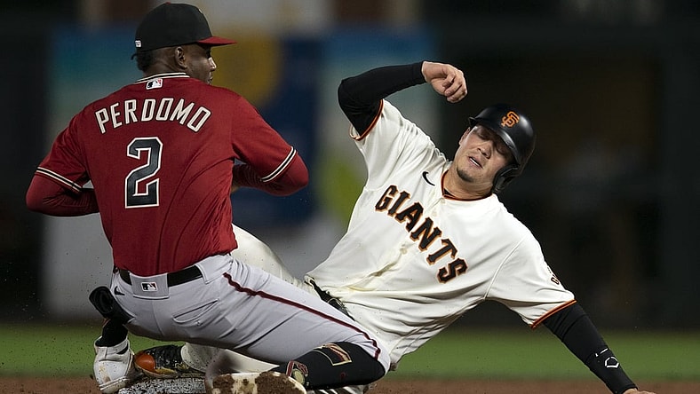 Sep 29, 2021; San Francisco, California, USA; Arizona Diamondbacks shortstop Geraldo Perdomo (2) takes the relay in time to force out San Francisco Giants first baseman Wilmer Flores (right) at second base during the second inning at Oracle Park. Mandatory Credit: D. Ross Cameron-USA TODAY Sports
