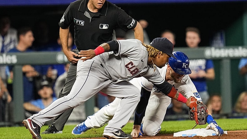 Sep 29, 2021; Kansas City, Missouri, USA; Kansas City Royals first baseman Hunter Dozier (17) reaches third base safely as Cleveland Indians third baseman Jose Ramirez (11) applies the tag during the seventh inning at Kauffman Stadium. Mandatory Credit: Jay Biggerstaff-USA TODAY Sports