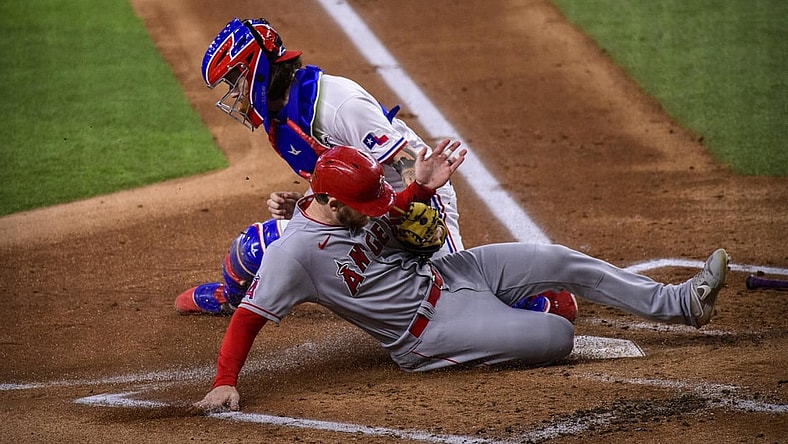 Sep 30, 2021; Arlington, Texas, USA; Los Angeles Angels left fielder Taylor Ward (3) slides safely into home plate as Texas Rangers catcher Jonah Heim (28) cannot make the tag during the first inning at Globe Life Field. Mandatory Credit: Jerome Miron-USA TODAY Sports