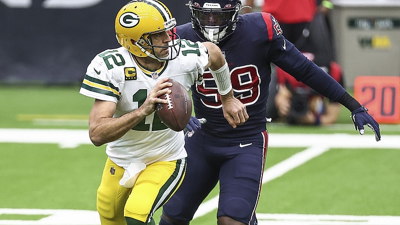 Oct 25, 2020; Houston, Texas, USA; Green Bay Packers quarterback Aaron Rodgers (12) scrambles with the ball as Houston Texans outside linebacker Whitney Mercilus (59) defends during the first quarter at NRG Stadium. Mandatory Credit: Troy Taormina-USA TODAY Sports