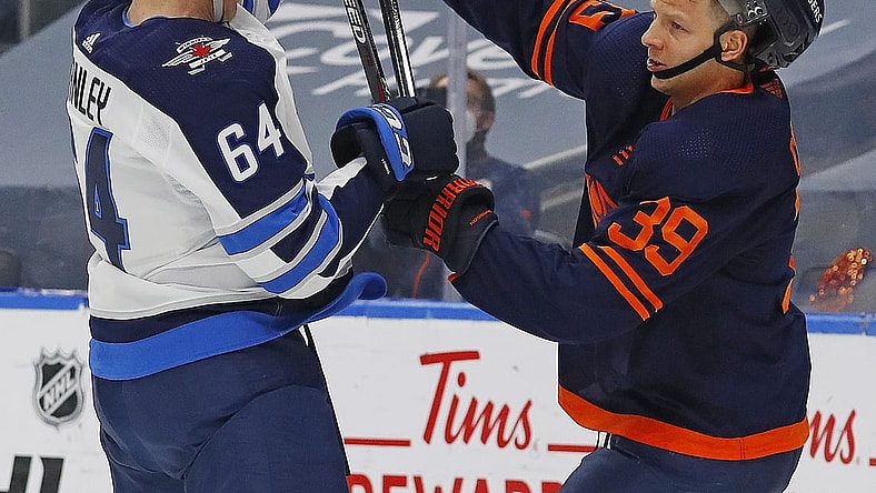 May 21, 2021; Edmonton, Alberta, CAN; Winnipeg Jets defensemen Logan Stanley (64) and Edmonton Oilers forward Alex Chiasson (39) battle for position during the first period in game two of the first round of the 2021 Stanley Cup Playoffs at Rogers Place. Mandatory Credit: Perry Nelson-USA TODAY Sports