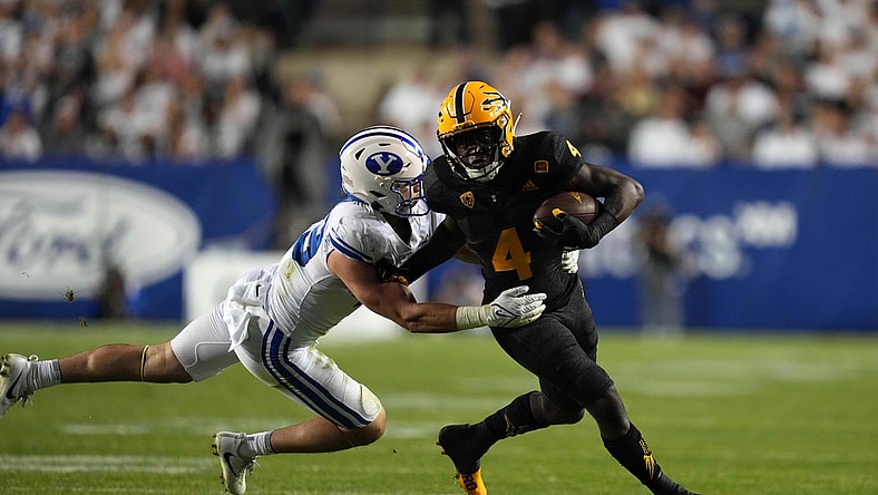 Sep 18, 2021; Provo, Utah, USA; Arizona State Sun Devils running back Daniyel Ngata (4) is defended by BYU Cougars linebacker Payton Wilgar (49) in the second half at LaVell Edwards Stadium. Mandatory Credit: Kirby Lee-USA TODAY Sports