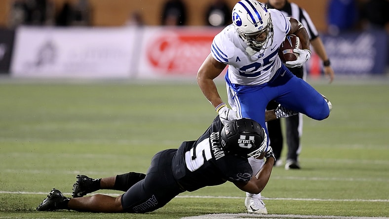 Oct 1, 2021; Logan, Utah, USA; Utah State Aggies linebacker Cash Gilliam (5) tackles Brigham Young Cougars running back Tyler Allgeier (25) during the third quarter at Merlin Olsen Field at Maverik Stadium. Mandatory Credit: Rob Gray-USA TODAY Sports