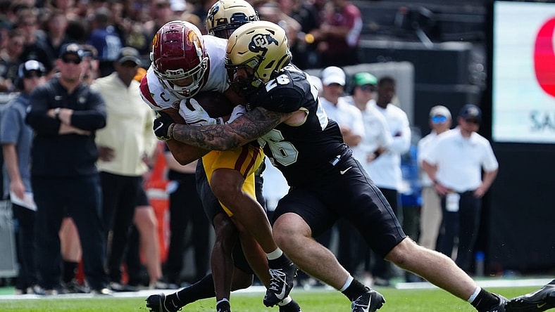 Oct 2, 2021; Boulder, Colorado, USA; Colorado Buffaloes linebacker Carson Wells (26) tackles USC Trojans wide receiver Drake London (15) in the second quarter at Folsom Field. Mandatory Credit: Ron Chenoy-USA TODAY Sports