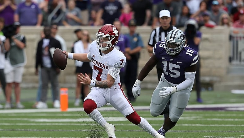 Oct 2, 2021; Manhattan, Kansas, USA; Oklahoma Sooners quarterback Spencer Rattler (7) runs away from Kansas State Wildcats defensive tackle Robert Hentz II (15) during the second quarter of a game at Bill Snyder Family Football Stadium. Mandatory Credit: Scott Sewell-USA TODAY Sports