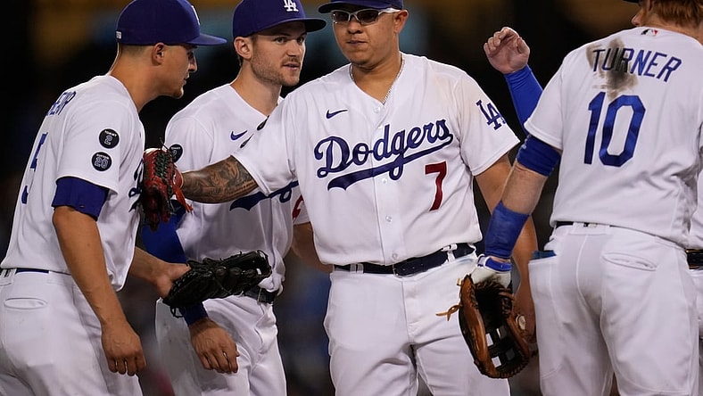 Oct 2, 2021; Los Angeles, California, USA; Los Angeles Dodgers starting pitcher Julio Urias (7) bumps the chest of shortstop Corey Seager (5) as he leaves the game against the Milwaukee Brewers in the seventh inning at Dodger Stadium. Urias left the game with a 7-1 lead as he was going for his Major League leading 20th win of the season. Mandatory Credit: Robert Hanashiro-USA TODAY Sports