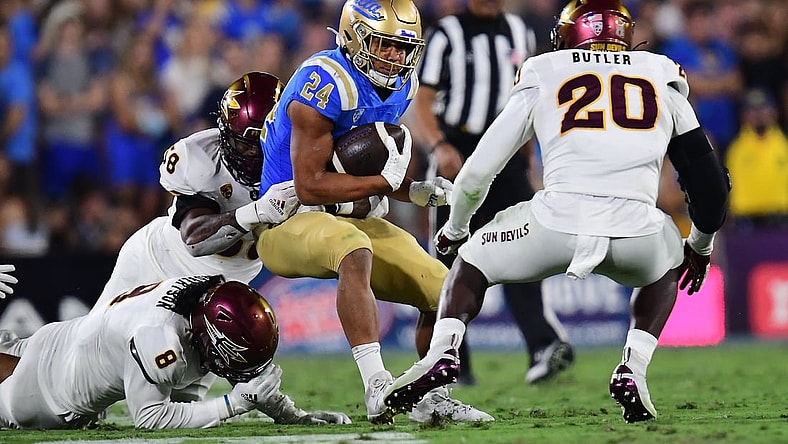 Oct 2, 2021; Pasadena, California, USA; UCLA Bruins running back Zach Charbonnet (24) runs the ball against Arizona State Sun Devils defensive lineman Joe Moore (58) linebacker Darien Butler (20) and linebacker Merlin Robertson (8) during the first half at Rose Bowl. Mandatory Credit: Gary A. Vasquez-USA TODAY Sports