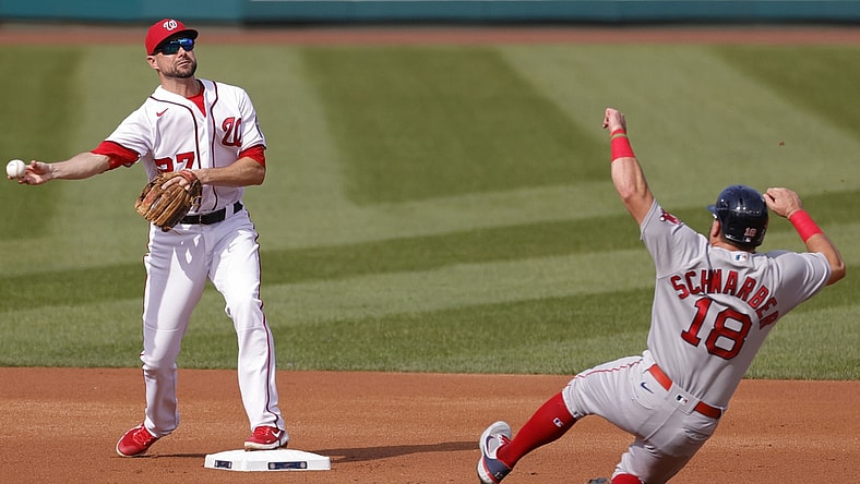 Oct 3, 2021; Washington, District of Columbia, USA; Washington Nationals shortstop Jordy Mercer (27) turns a double play ahead of the slide of Boston Red Sox left fielder Kyle Schwarber (18) during the first inning at Nationals Park. Mandatory Credit: Geoff Burke-USA TODAY Sports