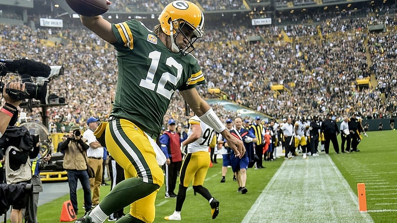 Oct 3, 2021; Green Bay, Wisconsin, USA; Green Bay Packers quarterback Aaron Rodgers (12) celebrates after scoring a touchdown in the second quarter against the Pittsburgh Steelers at Lambeau Field. Mandatory Credit: Benny Sieu-USA TODAY Sports