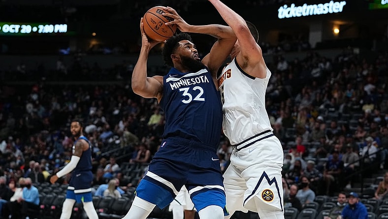 Oct 8, 2021; Denver, Colorado, USA; Minnesota Timberwolves center Karl-Anthony Towns (32) drives at Denver Nuggets center Nikola Jokic (15) in the third quarter at Ball Arena. Mandatory Credit: Ron Chenoy-USA TODAY Sports