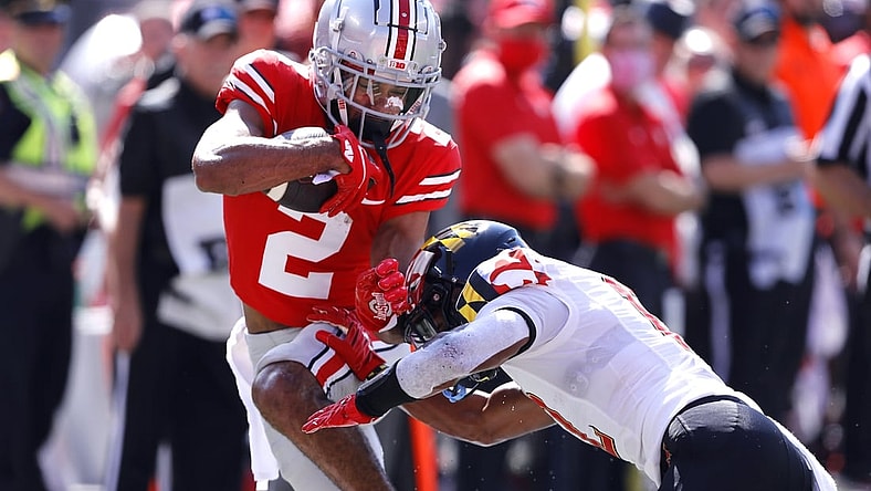 Oct 9, 2021; Columbus, Ohio, USA; Ohio State Buckeyes wide receiver Chris Olave (2) is tackled by Maryland Terrapins defensive back Tarheeb Still (12)during the first quarter at Ohio Stadium. Mandatory Credit: Joseph Maiorana-USA TODAY Sports