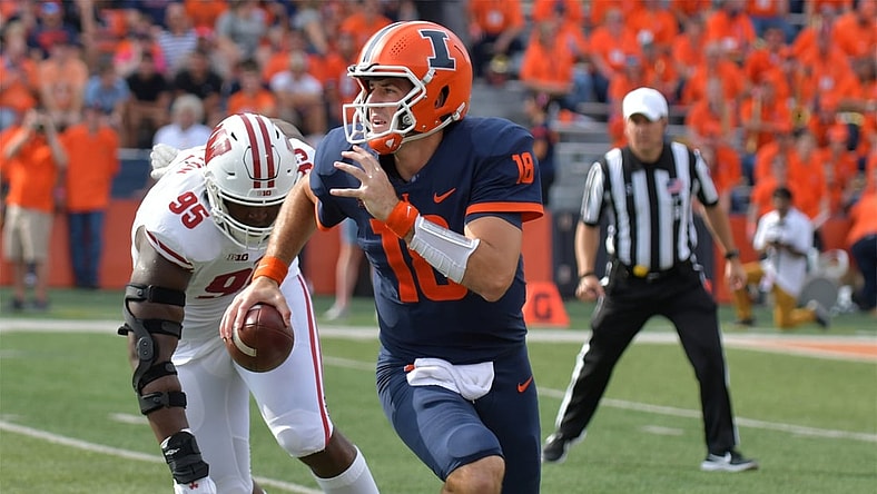Oct 9, 2021; Champaign, Illinois, USA;  Illinois Fighting Illini quarterback Brandon Peters (18) runs with the ball as Wisconsin Badgers defensive tackle Keeanu Benton (95) pursues in the first half at Memorial Stadium. Mandatory Credit: Ron Johnson-USA TODAY Sports
