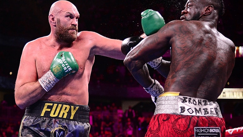 Oct 9, 2021; Las Vegas, Nevada, USA; Deontay Wilder (red/black trunks) and Tyson Fury (black/gold trunks) box during their WBC/Lineal heavyweight championship boxing match at T-Mobile Arena. Mandatory Credit: Joe Camporeale-USA TODAY Sports