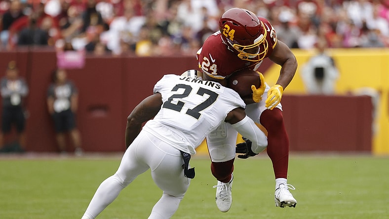 Oct 10, 2021; Landover, Maryland, USA; Washington Football Team running back Antonio Gibson (24) is tackled while carrying the ball by New Orleans Saints safety Malcolm Jenkins (27) during the first quarter at FedExField. Mandatory Credit: Geoff Burke-USA TODAY Sports