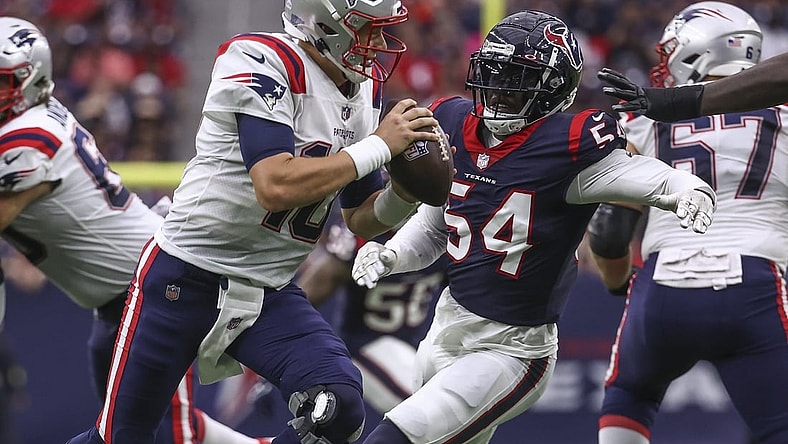 Oct 10, 2021; Houston, Texas, USA; New England Patriots quarterback Mac Jones (10) scrambles with the ball as Houston Texans defensive end Jake Martin (54) defends during the second quarter at NRG Stadium. Mandatory Credit: Troy Taormina-USA TODAY Sports