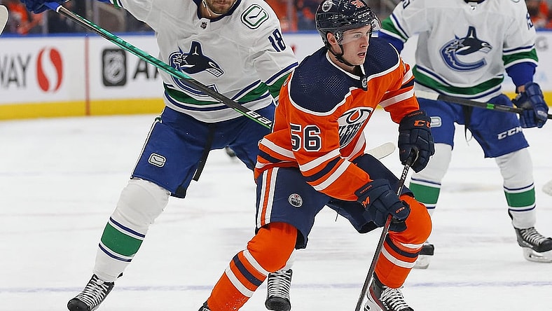 Oct 13, 2021; Edmonton, Alberta, CAN; Edmonton Oilers forward Kailer Yamamoto (56) is chased by Vancouver Canucks forward Jason Dickinson (18) during the first period at Rogers Place. Mandatory Credit: Perry Nelson-USA TODAY Sports
