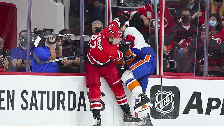 Oct 14, 2021; Raleigh, North Carolina, USA; Carolina Hurricanes center Jesperi Kotkaniemi (82) checks New York Islanders defenseman Ryan Pulock (6) during the first period at PNC Arena. Mandatory Credit: James Guillory-USA TODAY Sports