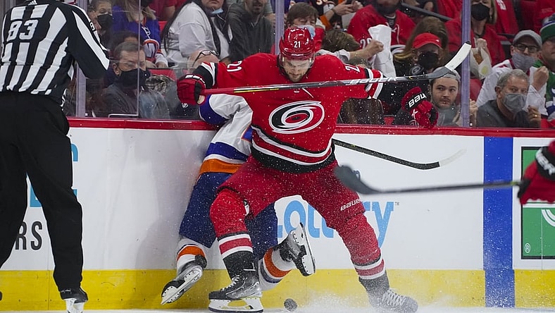 Oct 14, 2021; Raleigh, North Carolina, USA; Carolina Hurricanes right wing Nino Niederreiter (21) checks New York Islanders right wing Kyle Palmieri (21) during the first period at PNC Arena. Mandatory Credit: James Guillory-USA TODAY Sports