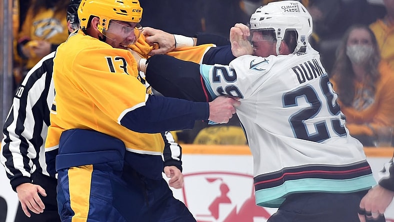 Oct 14, 2021; Nashville, Tennessee, USA; Nashville Predators center Yakov Trenin (13) and Seattle Kraken defenseman Vince Dunn (29) exchange punches during a fight during the first period at Bridgestone Arena. Mandatory Credit: Christopher Hanewinckel-USA TODAY Sports